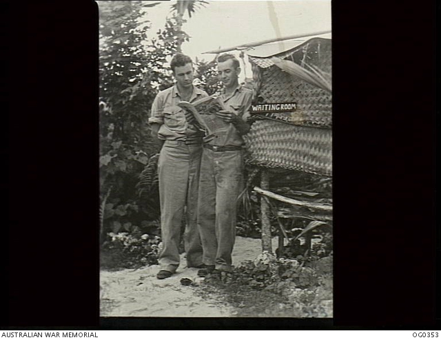 NEW GUINEA C 1944 05 TWO AIRMEN READING A PAPER IN THE OUTSIDE 