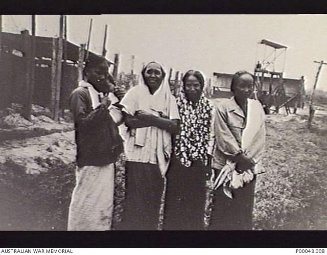 SOME LOCAL WOMEN NEAR THE PRISONER OF WAR (POW) COMPOUND WHICH HOUSED ...