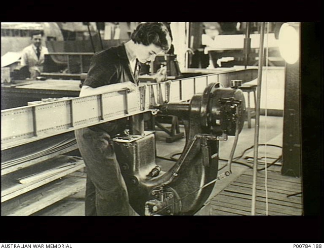 c. 1944. A woman factory worker rivets a spar for a Beaufighter ...