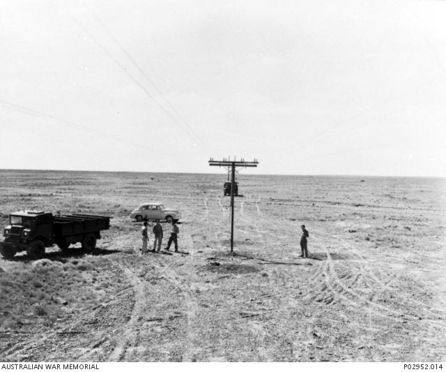 Woomera, SA. c. 1947. Four men standing under the telephone lines