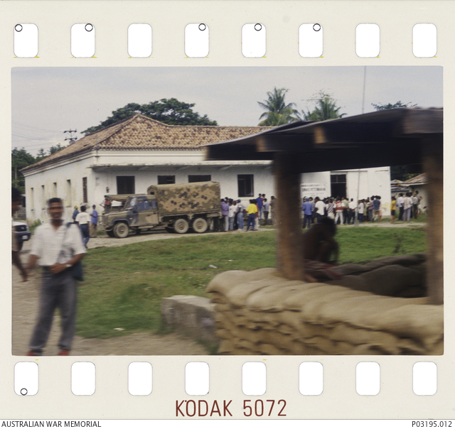 East Timorese lining up for jobs outside a building near an ...