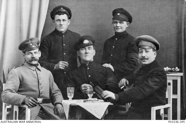 Studio portrait of four allied Prisoners of War (POW) posing with an ...