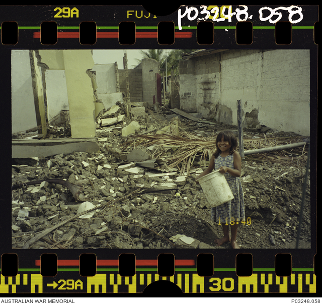 Dili, East Timor. 20 December 1999. A young Timorese girl scavenging ...