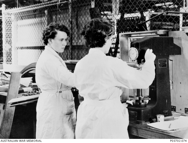 Two unidentified female technicians, using a machine for testing for ...