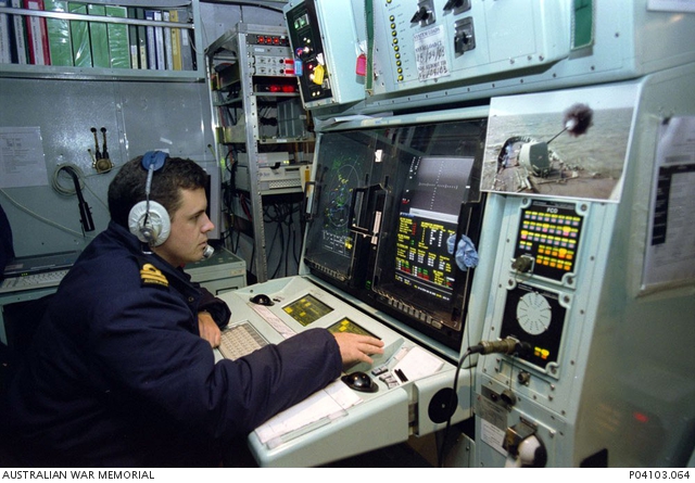 Lieutenant Sam Drummond, wearing a headset, operates a computer in ...
