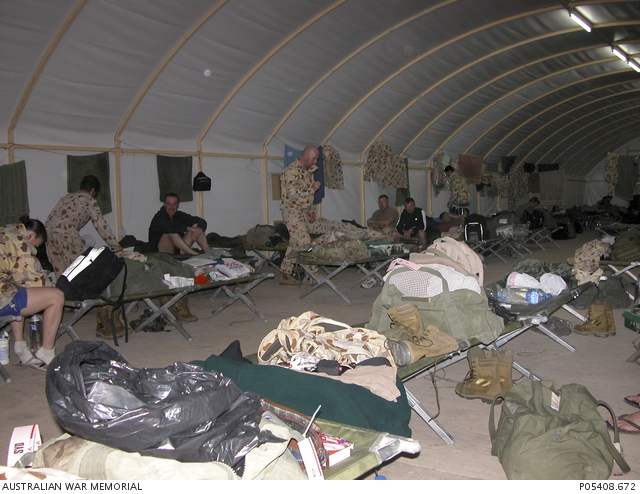 Australian soldiers and their belongings on stretcher beds in a large ...