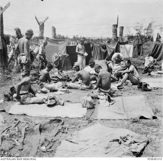 Once the aggressors, these Japanese prisoners of war (POWs) sit around ...
