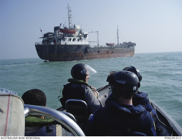 A boarding party deployed from HMAS Parramatta approaching a ship in a ...