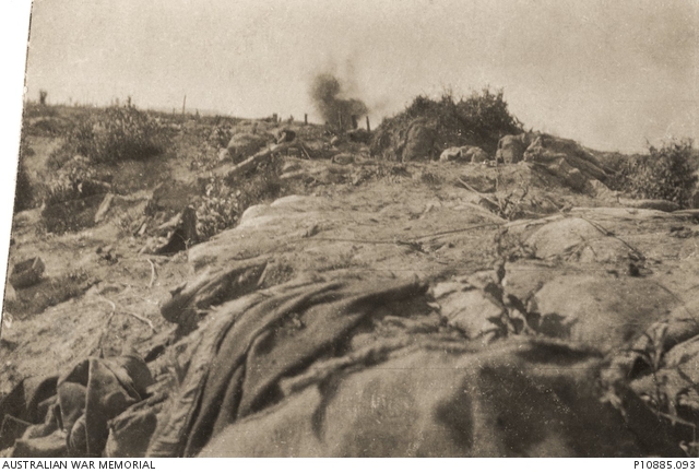 An enemy shell bursts in the distance above the Messines battlefield at ...