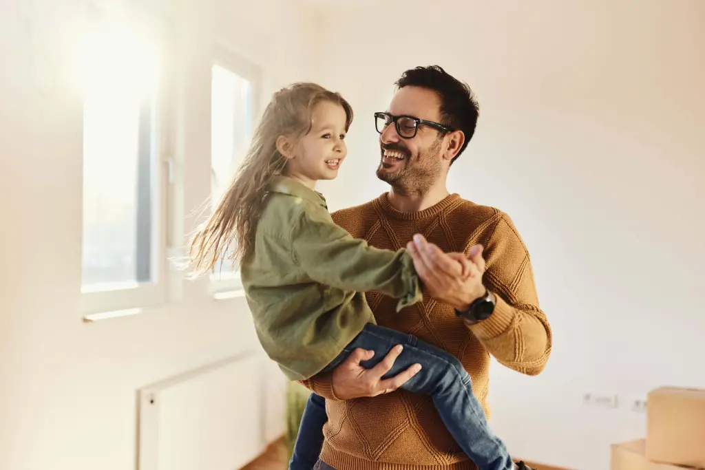 Father holding his daughter inside a new home after moving with Kent Removals & Storage