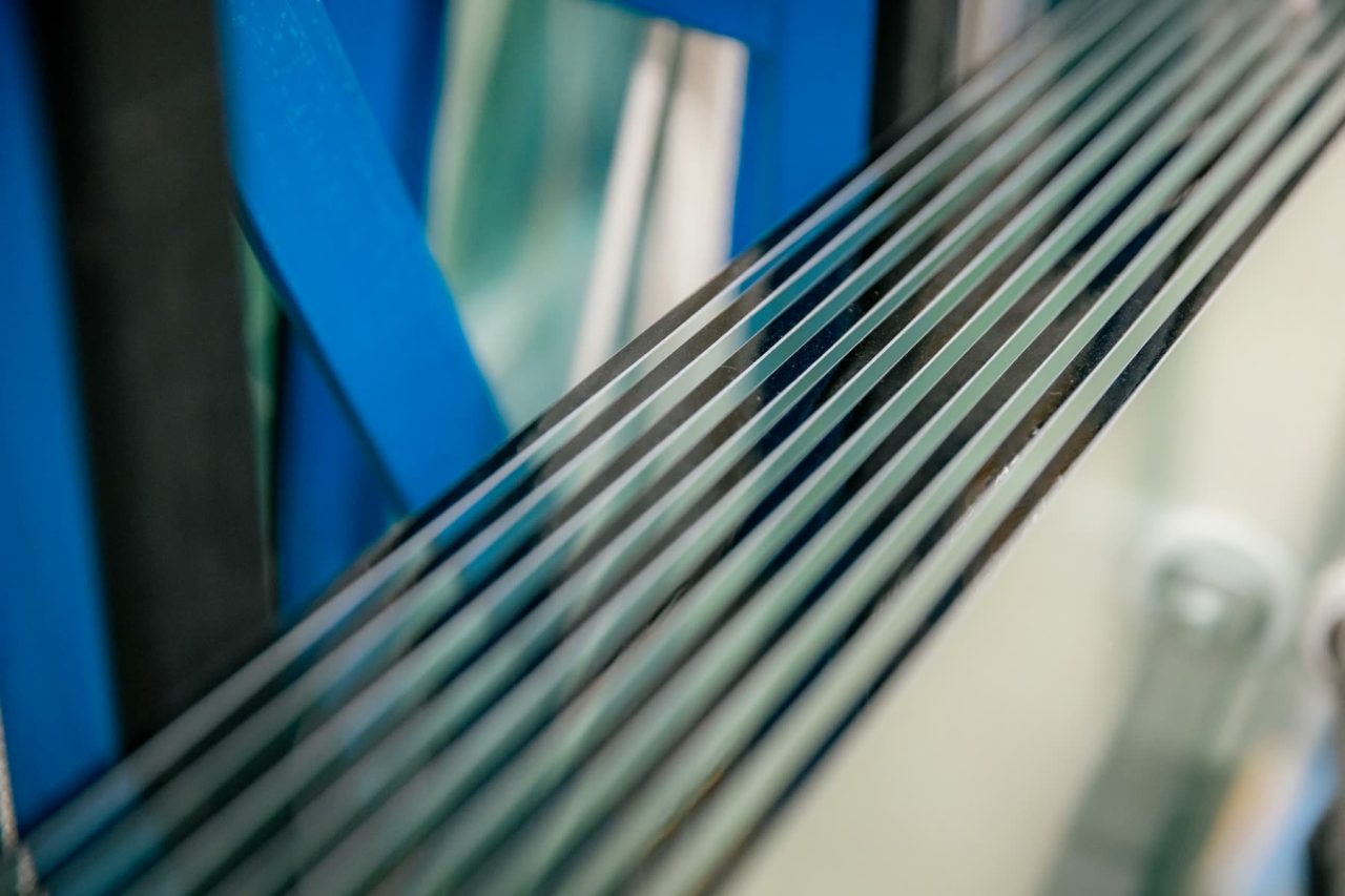 Close-up of stacked glass sheets showing different edge profiles and thicknesses.