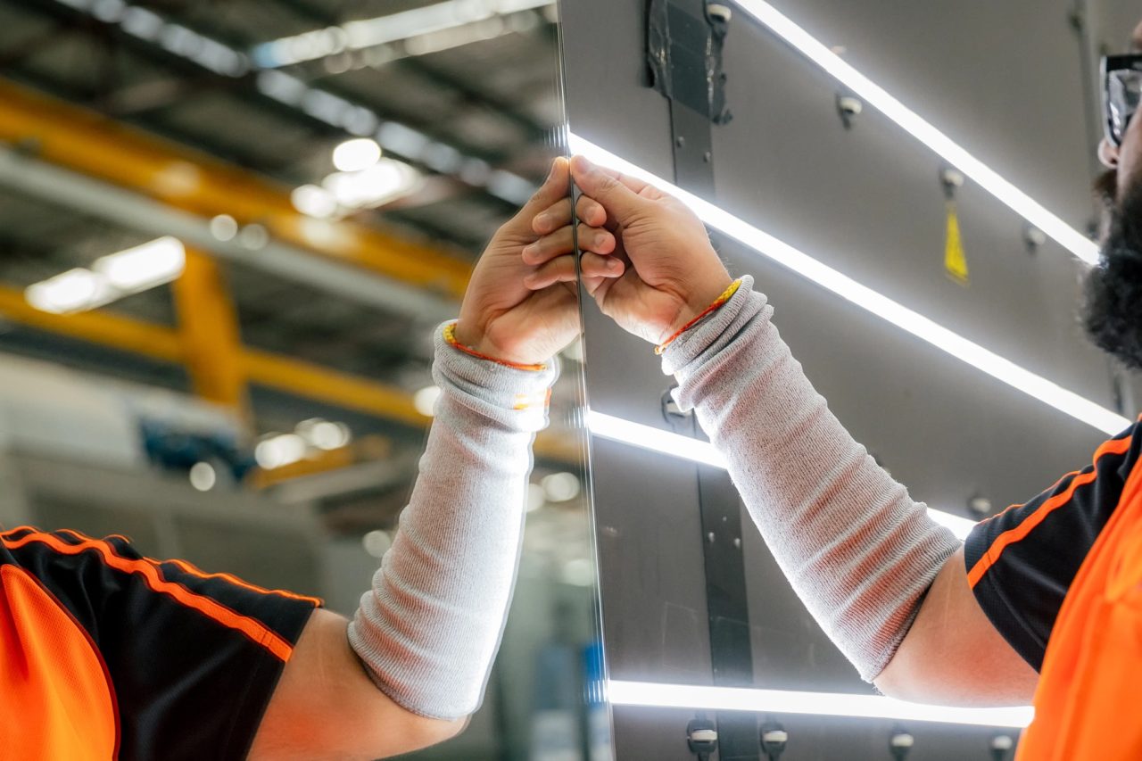 Tough Glass technicians aligning the edges of a large glass panel.