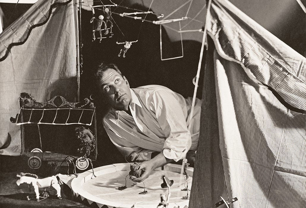 Alexander Calder in his studio, laying on floor looking up at circus sculpture. Detail: (Photo by George Hoyningen-Huene/Condé Nast via Getty Images)