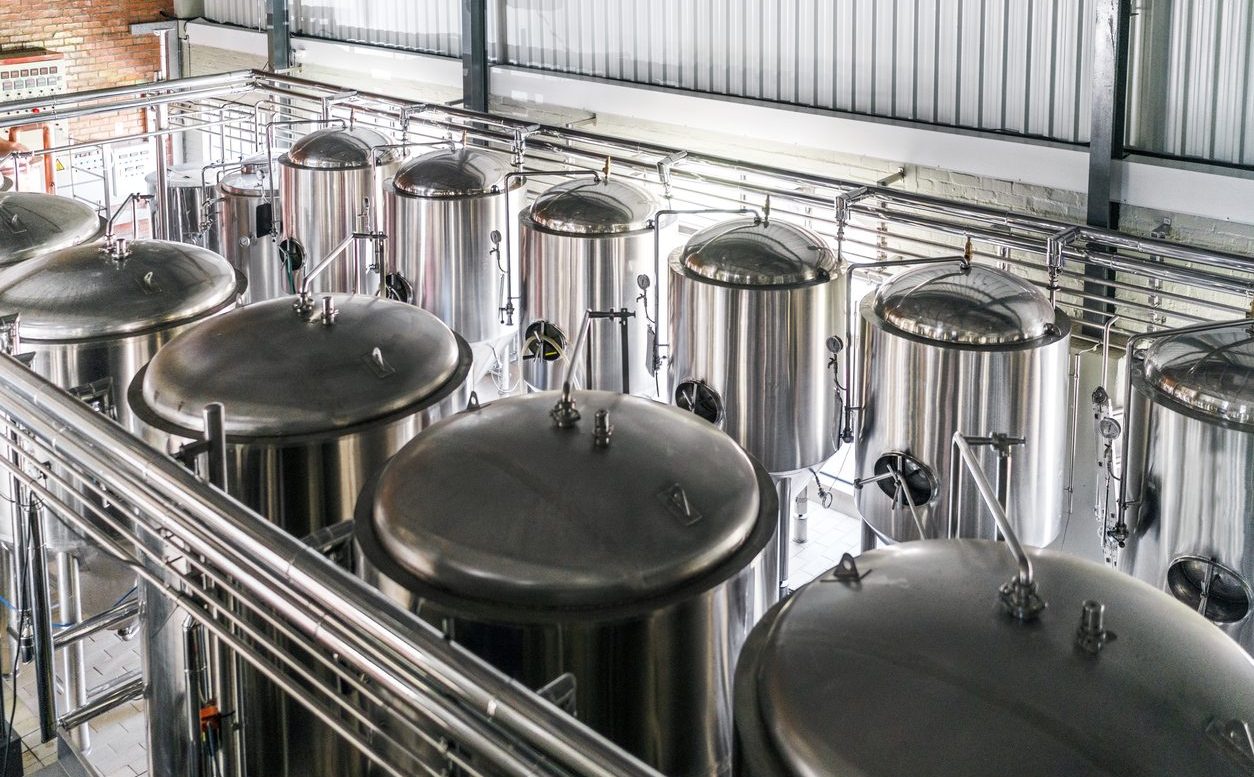 Rent relief in sight for commercial tenants Metallic vats in brewery. High angle view of steel containers in factory. Beer is stored in huge storage tanks at industry.