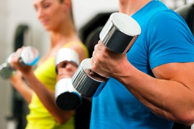 couple lifting weights in a gym