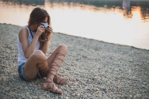 Girl sitting on the beach and photographing
