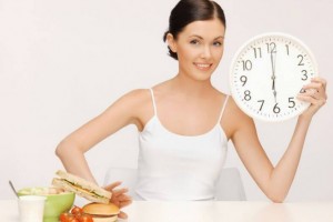 picture of woman with big clock pushing food away