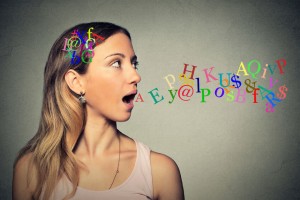 woman talking with alphabet letters in her head and coming out of her open mouth