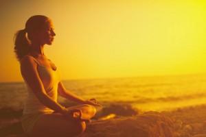 woman on the beach practising meditation