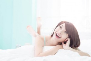 happy woman lying in bed and awake