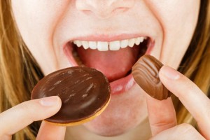 Close up photo of beautiful young lady eating candy