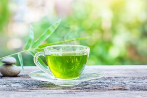 cup of gree tea on wooden table
