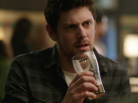 Man with a beer in his hand and a questioning look on his face
