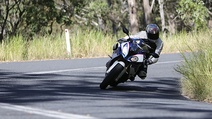 View of rider on BMW motorcycle leaning into corner