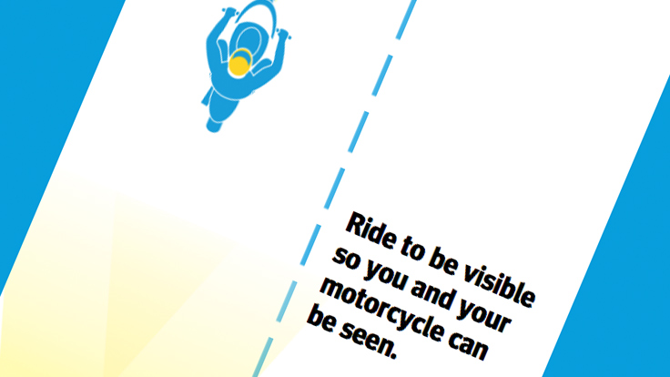 Top down view of cartoon motorcycle rider on one side of the dotted line with text on the other side saying: Ride to be visible so you and your motorcycle can be seen.