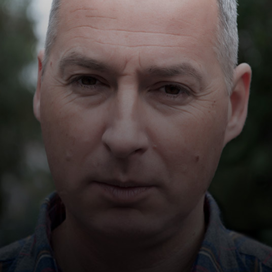 Portrait of elderly man staring at camera with a slightly serious look on his face
