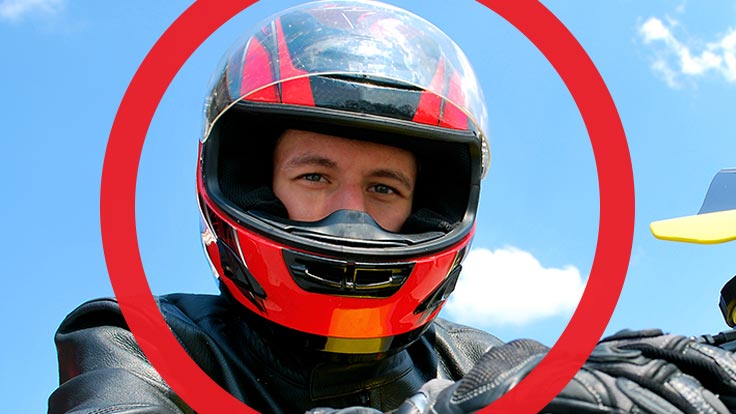 Portrait of man wearing motorcycle helmet with thick red circle framing his face