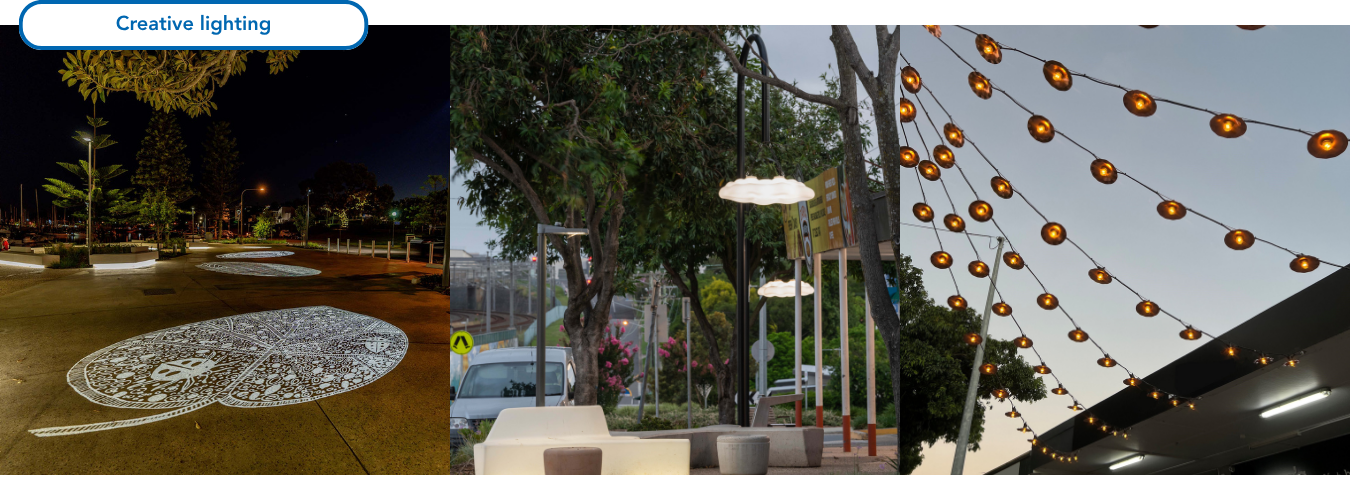 Image of a streetscape with three large scale artworks projected onto a footpath adjacent a seating area. The intricate artworks shine brightly, creatively highlighting the area’s history, and assisting with wayfaring and evening activation of the neighbourhood streetscape.  Image of a streetscape creatively illuminated for evening activation with two cloud shaped street lights floating above a seating area composed of twig shaped seats and concrete stools. Close up of illuminated catenary lighting creating a warm glow against the dusk sky. The lights with metal shades are staggered along eight strings installed across a footpath creating ambience to the local neighbourhood centre. 