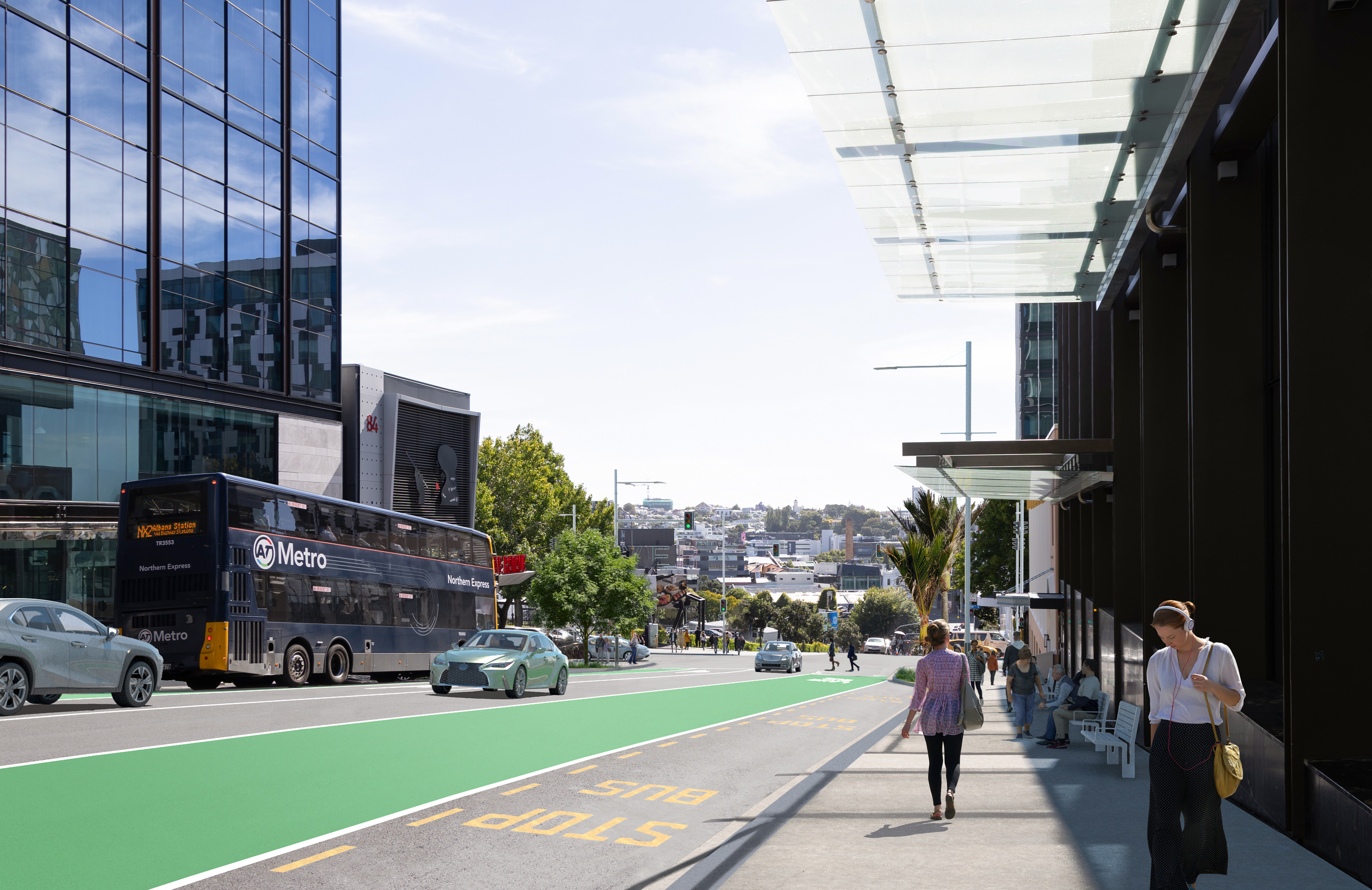 Woman wearing headphones by bus shelter.