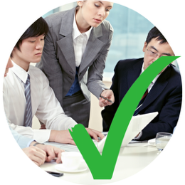 three people looking over document with a green tick