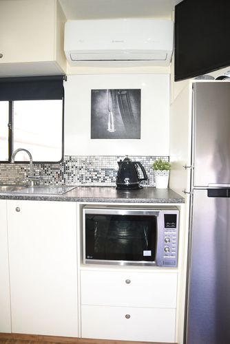“I am too busy riding horses to cook,” says Ali. The microwave is a convection oven as well, so there is some possibility. “We have a BBQ and can set up a Sunbeam frypan in the horse section and bring the food in from there, to avoid cooking fumes in the living,” says Vicki Berwick. The split system air conditioner is above the kitchen bench.