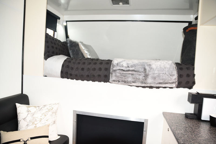 The queen bed in the luton. As with the bed over the bathroom, it is possible to sit up in bed and read due to the extra height of the truck, reading lights provided. To access the engine for servicing the luton bed comes out and hydraulics lift the cab.