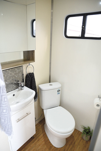 The hand basin and proper household china toilet occupy one side of the bathroom. The truck carries 200 litres of fresh water and has a grey and black water tank. If plugged into mains water the plumbing for the bathroom, kitchen and outside tap works from the one inlet.