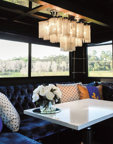 The 2.85m sildeout hosts couch seating and dining table which converts into a super king double bed if needed. The chandelier that hangs above is the main feature of the truck and is made up of small individual aluminium pieces, to create a two-tiered glow.