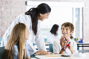 mum and teacher at school speaking to smiling young boy