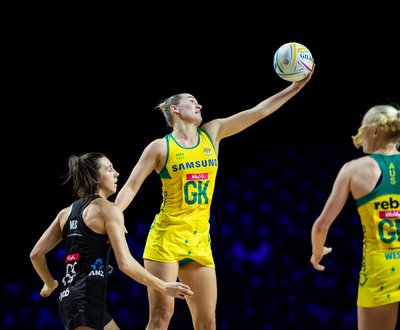 Bryce Courtney, goal keeper, holds ball while two netballers watch image