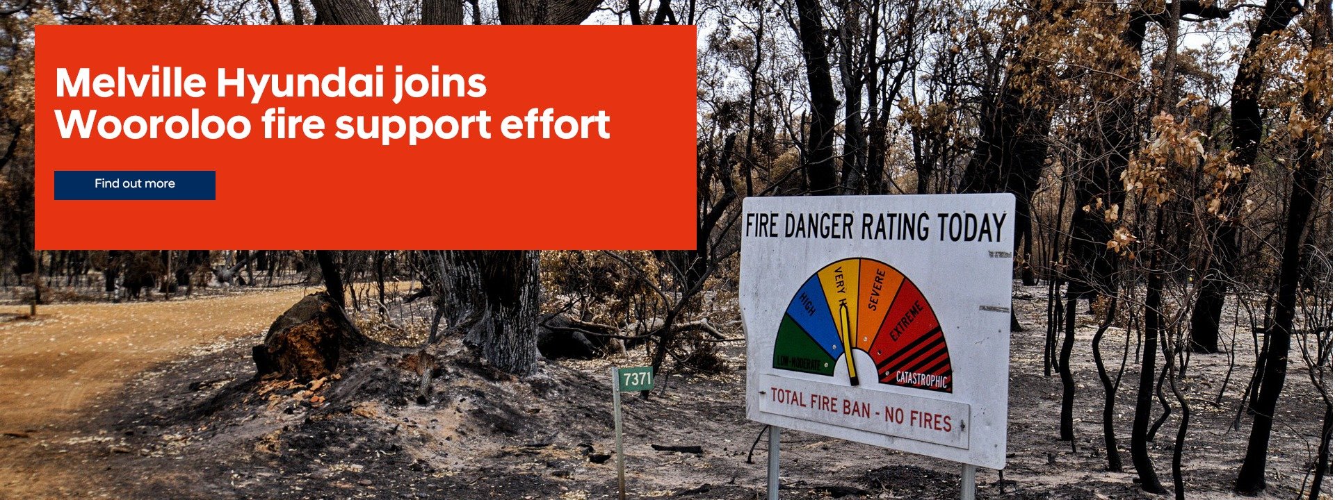 Patch of burnt bushland with fire danger sign standing off to one side