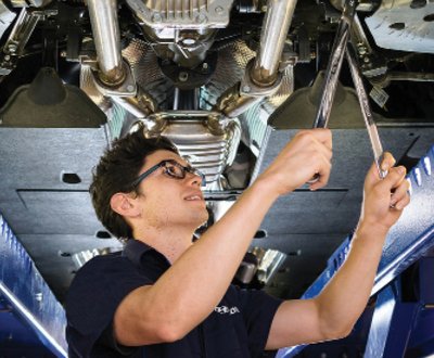 Technician servicing underside of car image