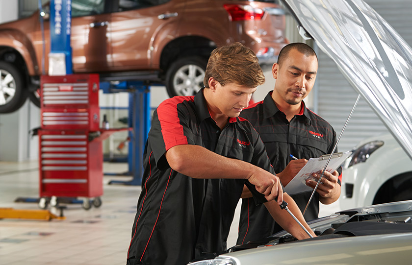 Two Isuzu UTE Service Plus technicians service the engine of an Isuzu Ute