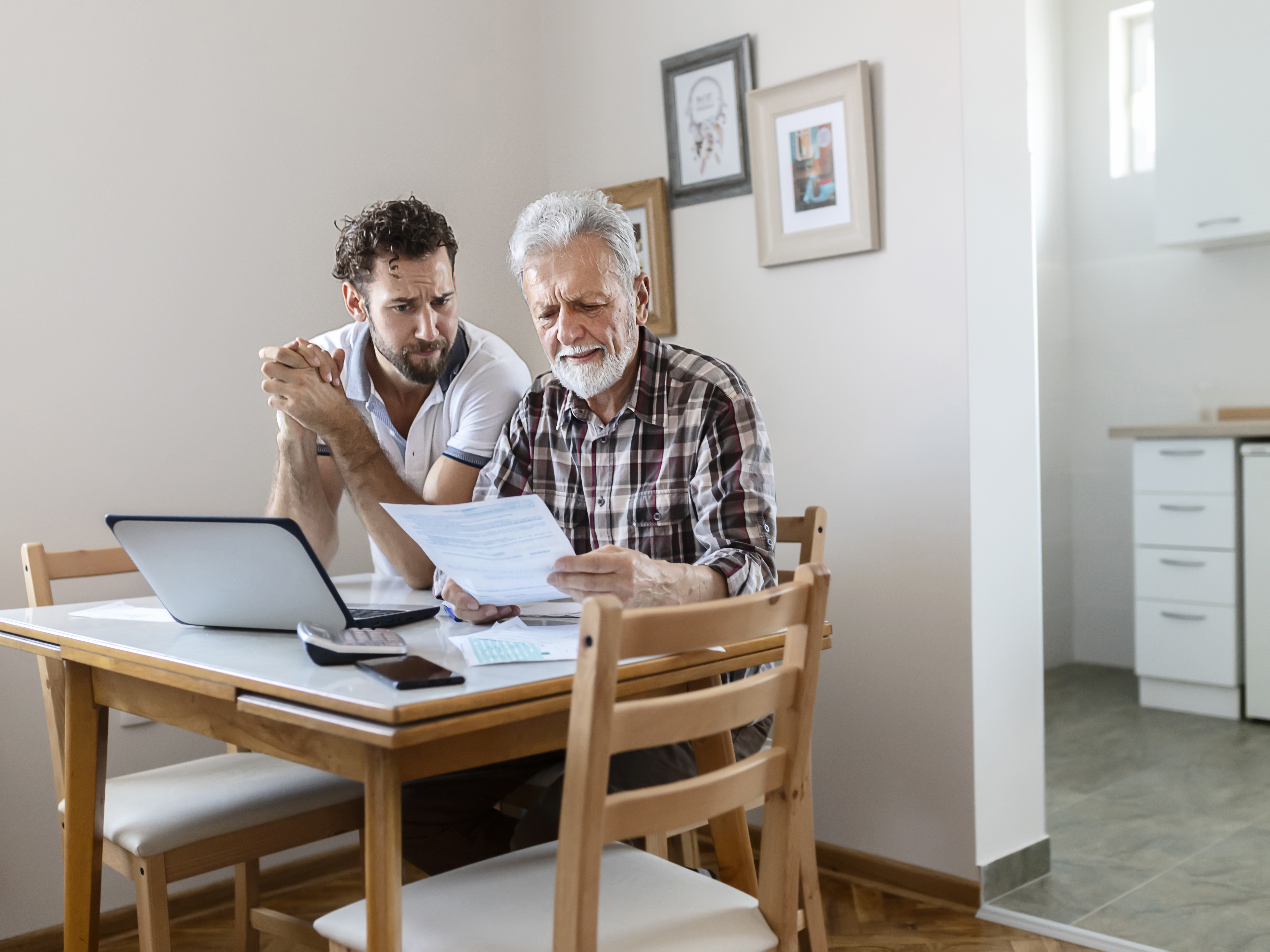 Older man going through his Advance Care Directive documents with his son.