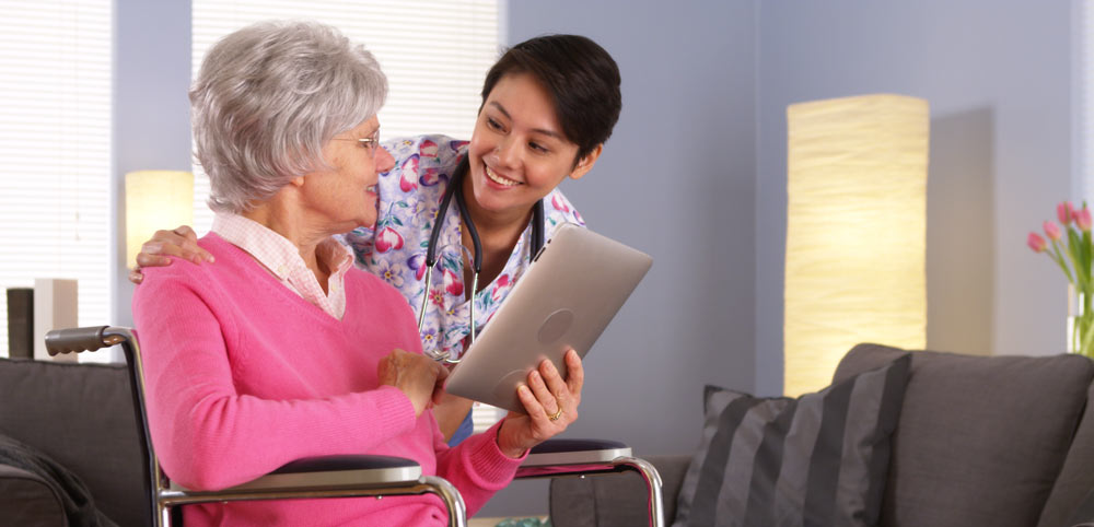 A woman talking with an aged carer in a nice home
