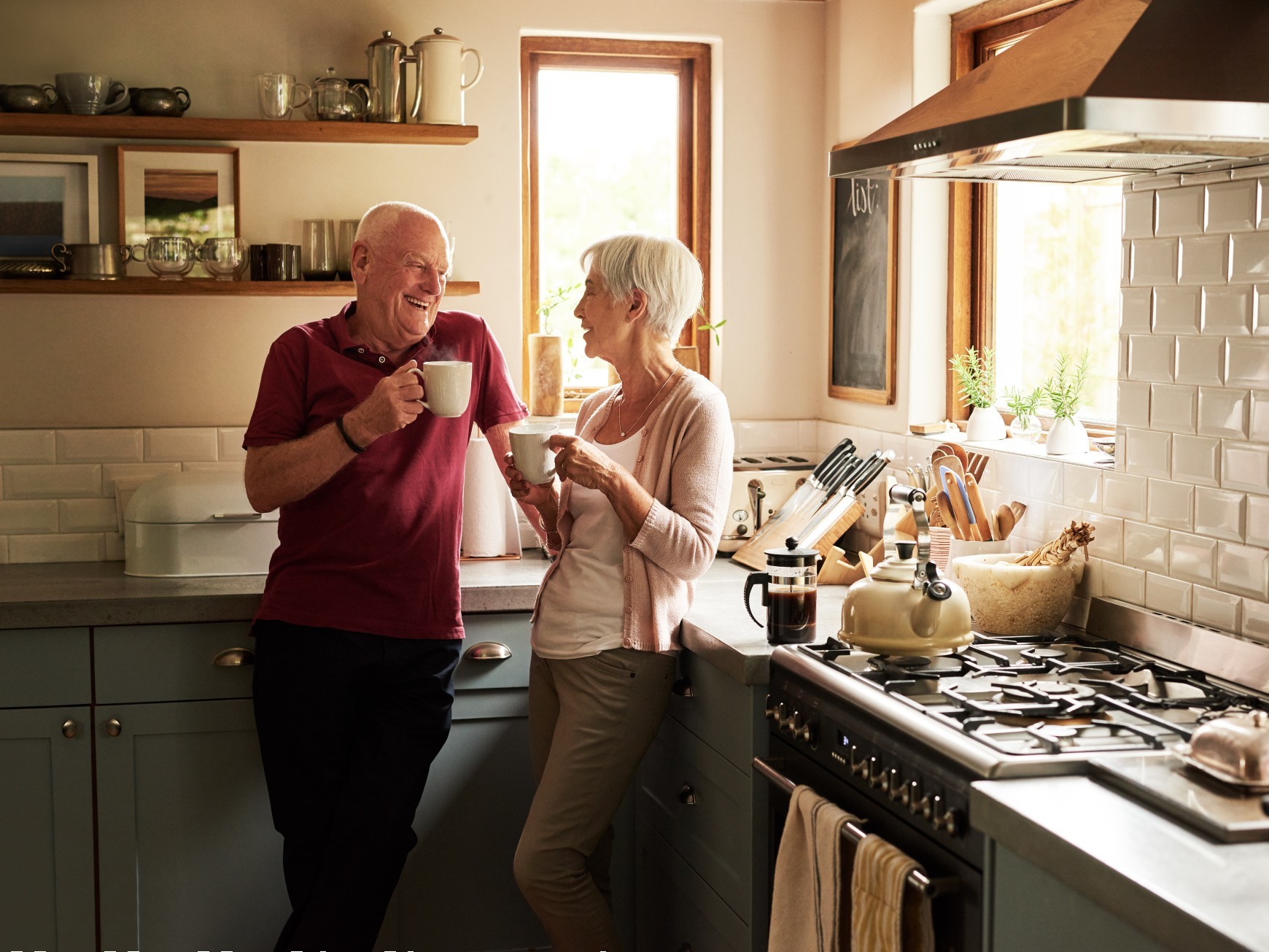 Soon to be retirees relaxing together in their kitchen with their morning coffee.