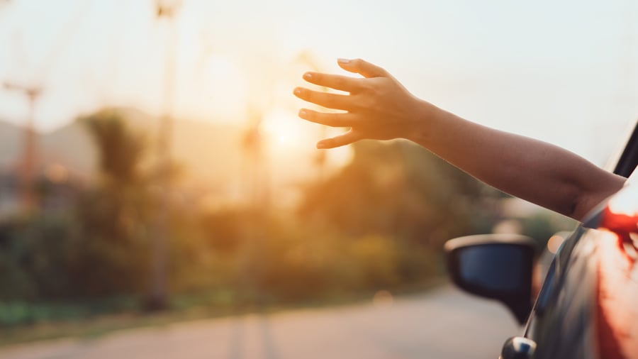 Hand stretched out of car window catching