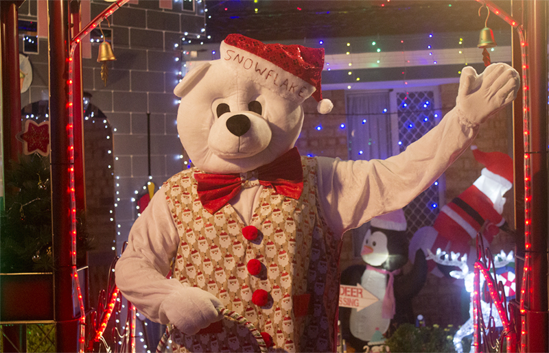 Person in polar bear costume with bow tie, vest and Santa hat