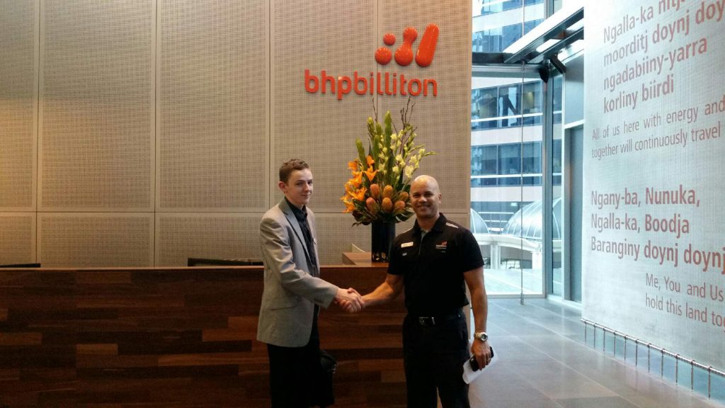 Jed shaking hands with Training Manager Bernie Reviere at the BHP office