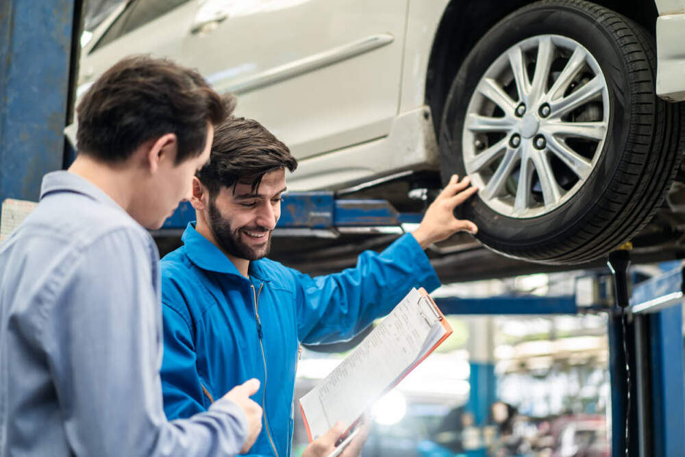 Customer and technician assessing the condition of a car tyre.